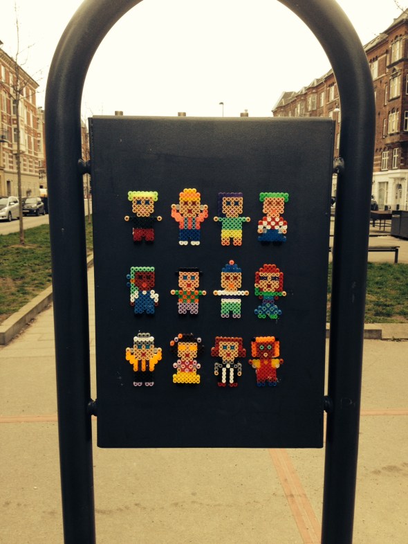 Beady figures on the back of the free dog poo bag stand